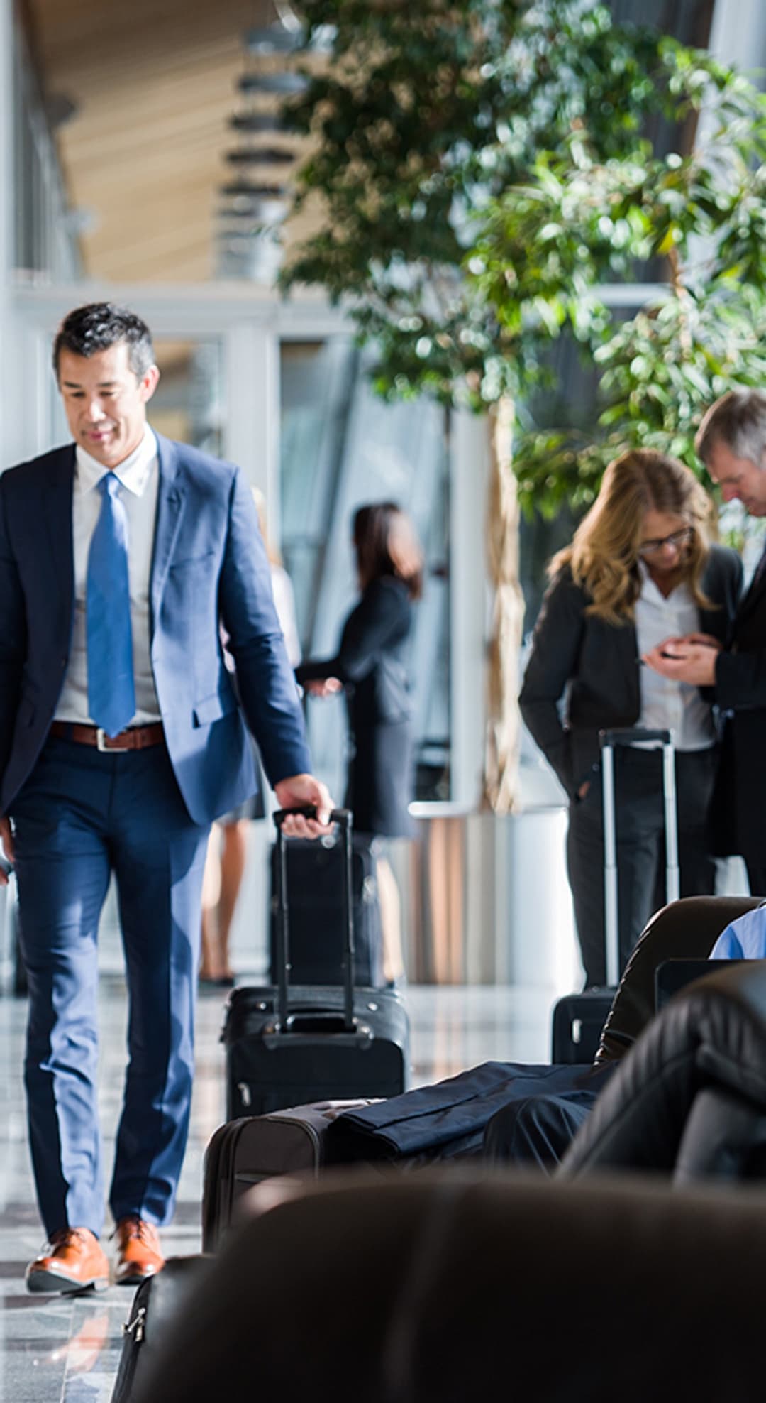 Professionals on the go: busy airport lounge with travelling business people.