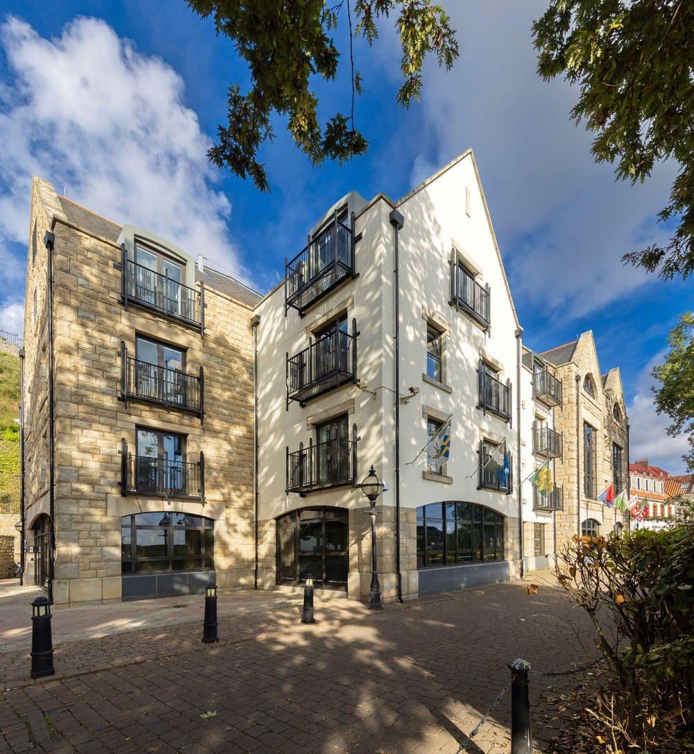 Outside of a building with numerous windows, allowing ample natural light to illuminate the interior.