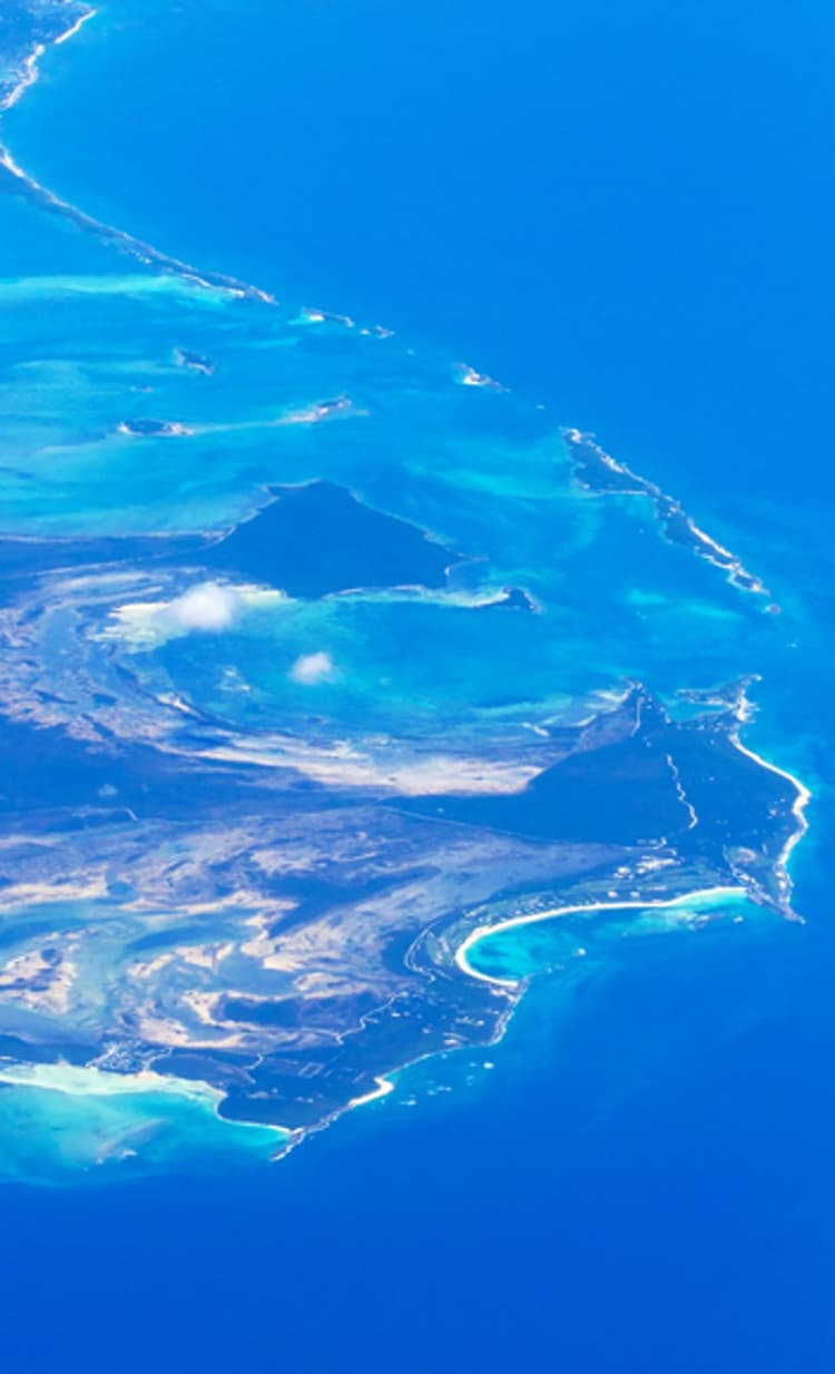 Rocky Island has green vegetation in the middle of a blue ocean.